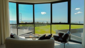 A modern living room with large windows, a sofa, and a coffee table. - Motel Heksapolis (Dilovasi)