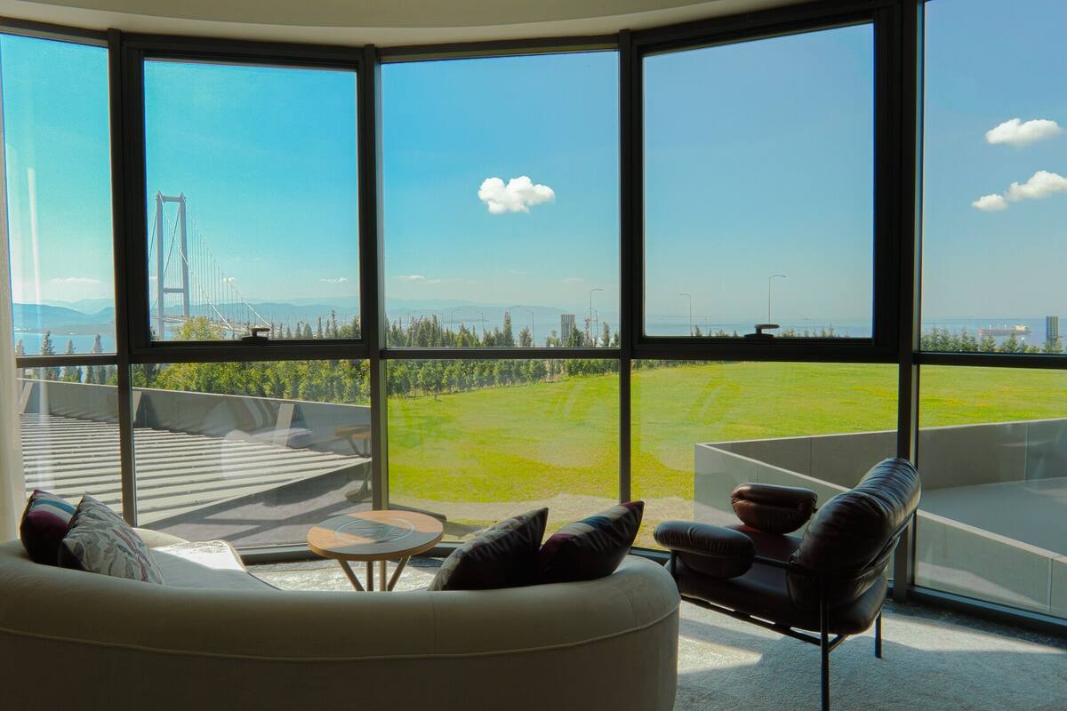 A modern living room with large windows, a sofa, and a coffee table.