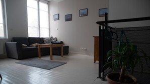 Un salon avec un canapé gris, une table basse en bois et une plante en pot.