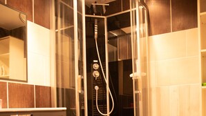 Une salle de bain moderne avec une douche à parois de verre, un meuble-lavabo en bois et un petit banc en bois.