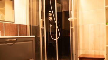 Une salle de bain moderne avec une douche à parois de verre, un meuble-lavabo en bois et un petit banc en bois.