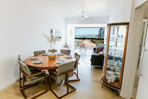 A dining area with a round table, chairs, and a glass cabinet with dishes.