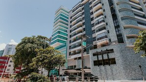 Un edificio de varios pisos con un diseño arquitectónico moderno, que cuenta con balcones y ventanas amplias.