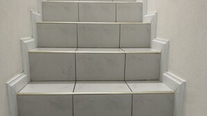 A set of white marble stairs with a handrail, leading to a landing. - Townhouse426 gated community (Portmore)