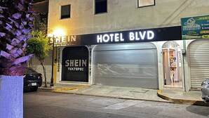 Un edificio con un letrero que dice 'HOTEL BLVD' y una puerta de garaje cerrada.