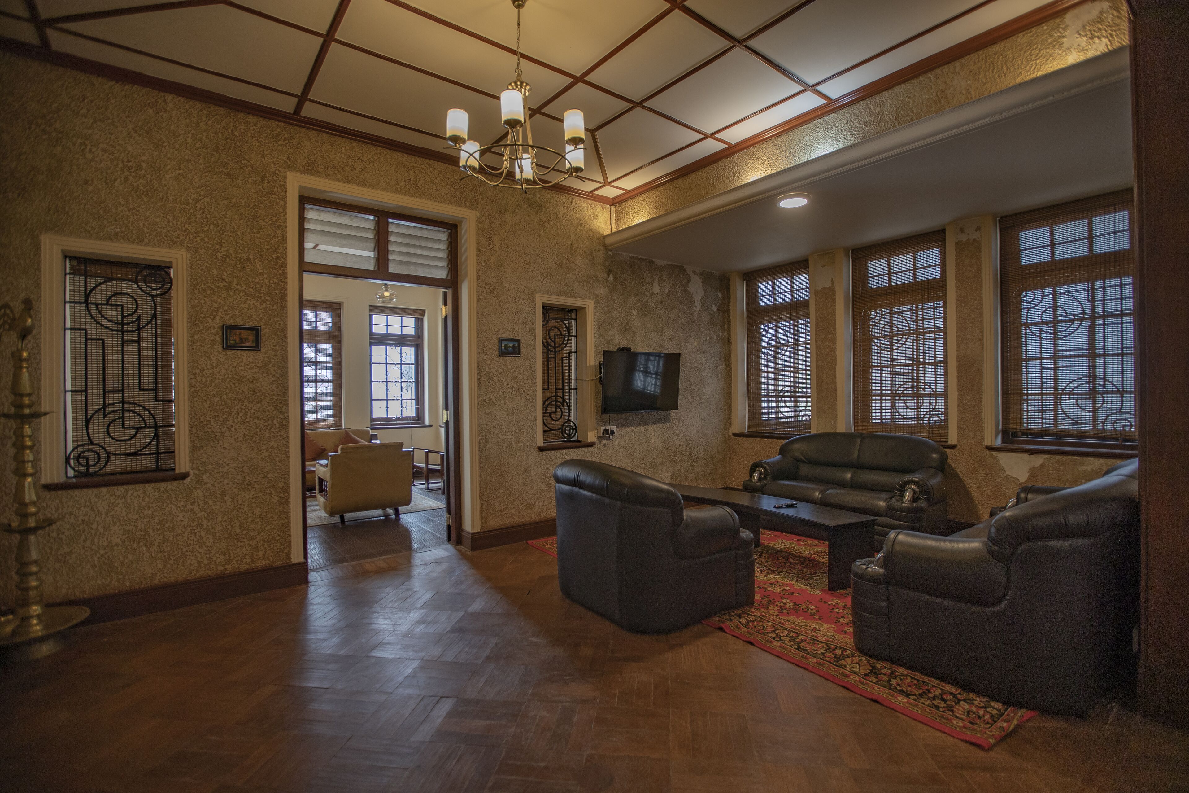 A spacious living room with a fireplace, leather sofas, and a television.