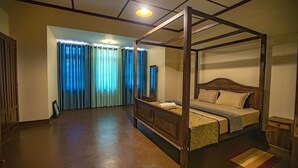 A four-poster bed with a wooden frame, a bedside table, and a nightstand. - Bandarawela City Bungalow (Bandarawela)