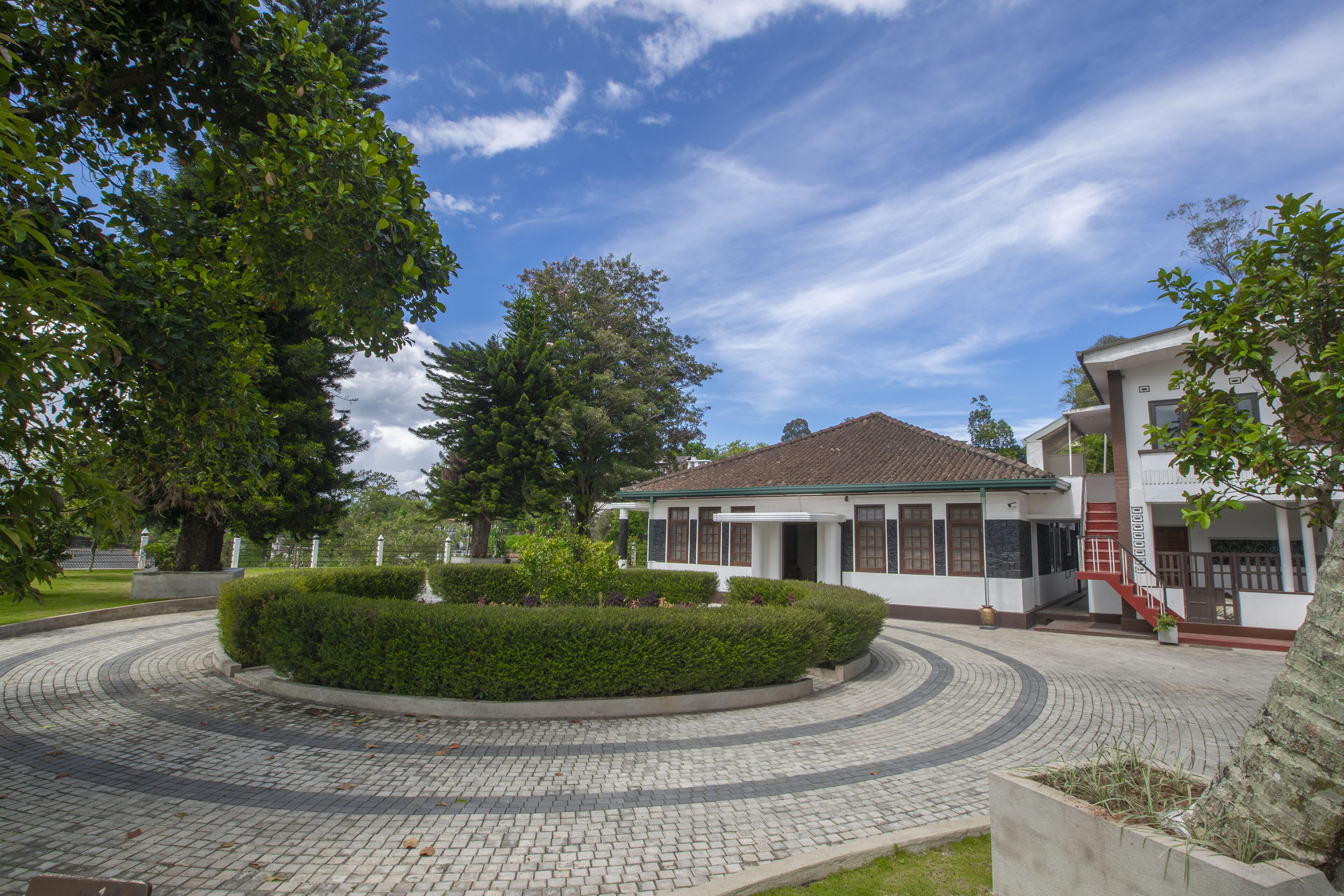 A courtyard with a circular brick pathway, a central fountain, and buildings with traditional architecture.