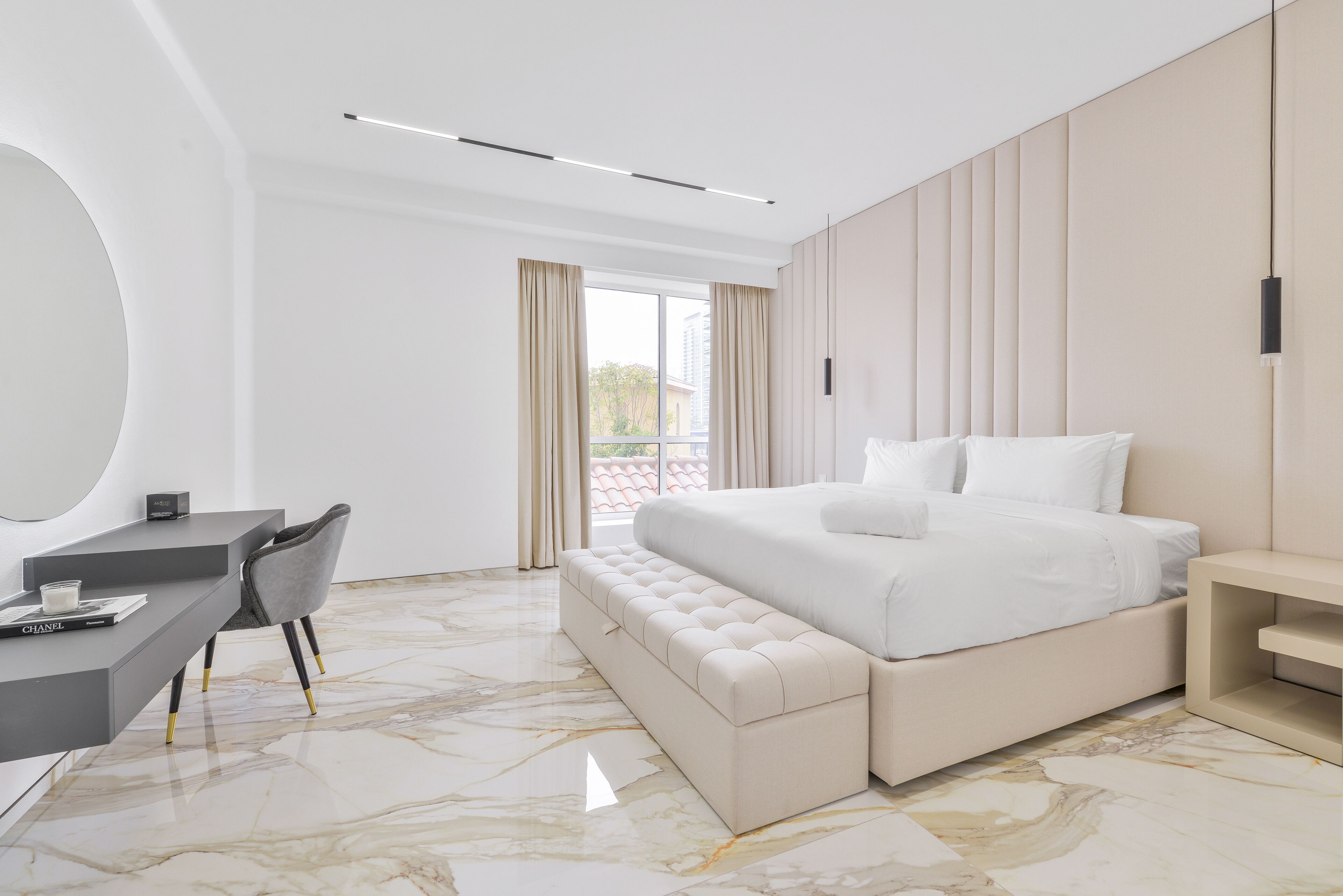 A modern bedroom with a bed, a desk, and a chair.