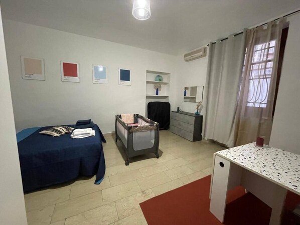 A hotel room with a bed, a desk, a dresser, a chair, and a small table. - Mimosa House - Turin (Torino)