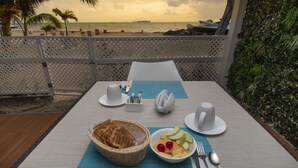 Una mesa lista para el desayuno con vista a la playa y al océano.