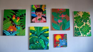 Seis cuadros con vibrantes motivos tropicales, incluyendo loros, un pavo real y abundante follaje.