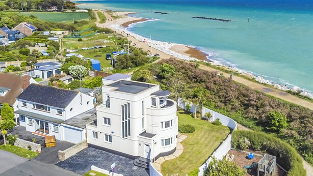 A coastal residential area with a modern two-story house, a beach, and a clear view of the sea. - 4 bedroom accommodation in Elmer (Elmer)