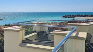 A rooftop terrace with a glass balustrade, outdoor seating, and a view of the ocean. - 4 bedroom accommodation in Elmer (Elmer)