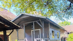 A wooden house with a balcony, a garden, and a paved area. - Walnußhof im Spreewald (Schmogrow-Fehrow)