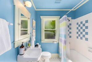 A bathroom with a blue wall, white sink, and toilet. - Enchanted Path to a Gardenscape (Seattle)