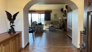 A spacious hallway with a tiled floor, wooden beams, and a statue of an eagle. - Incredible Views from Smith Point (Bradley)