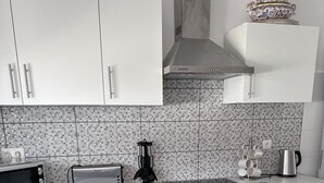 A modern kitchen with white cabinets, a Bosch oven, a toaster, and a coffee maker. - Cosy refurbished 3 bedroom Vila in a quiet area 2km  from town center (Lagos)