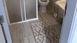A bathroom with a toilet, sink, and a shower area. - Cosy refurbished 3 bedroom Vila in a quiet area 2km  from town center (Lagos)