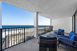 A balcony with wicker furniture and a view of the beach. - Wind Drift South East 404 (Orange Beach)