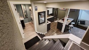 A modern interior with a kitchen, a dining area, and a staircase leading to another level.