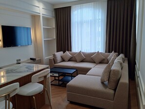 Suite Deluxe, bagno privato, vista città | Area soggiorno | TV LCD 42 pollici con canali satellitari, Smart TV