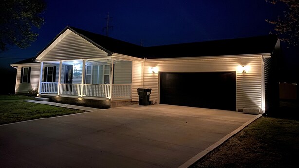 Ein zweigeschossiges Haus mit einer Veranda und einer Garage.