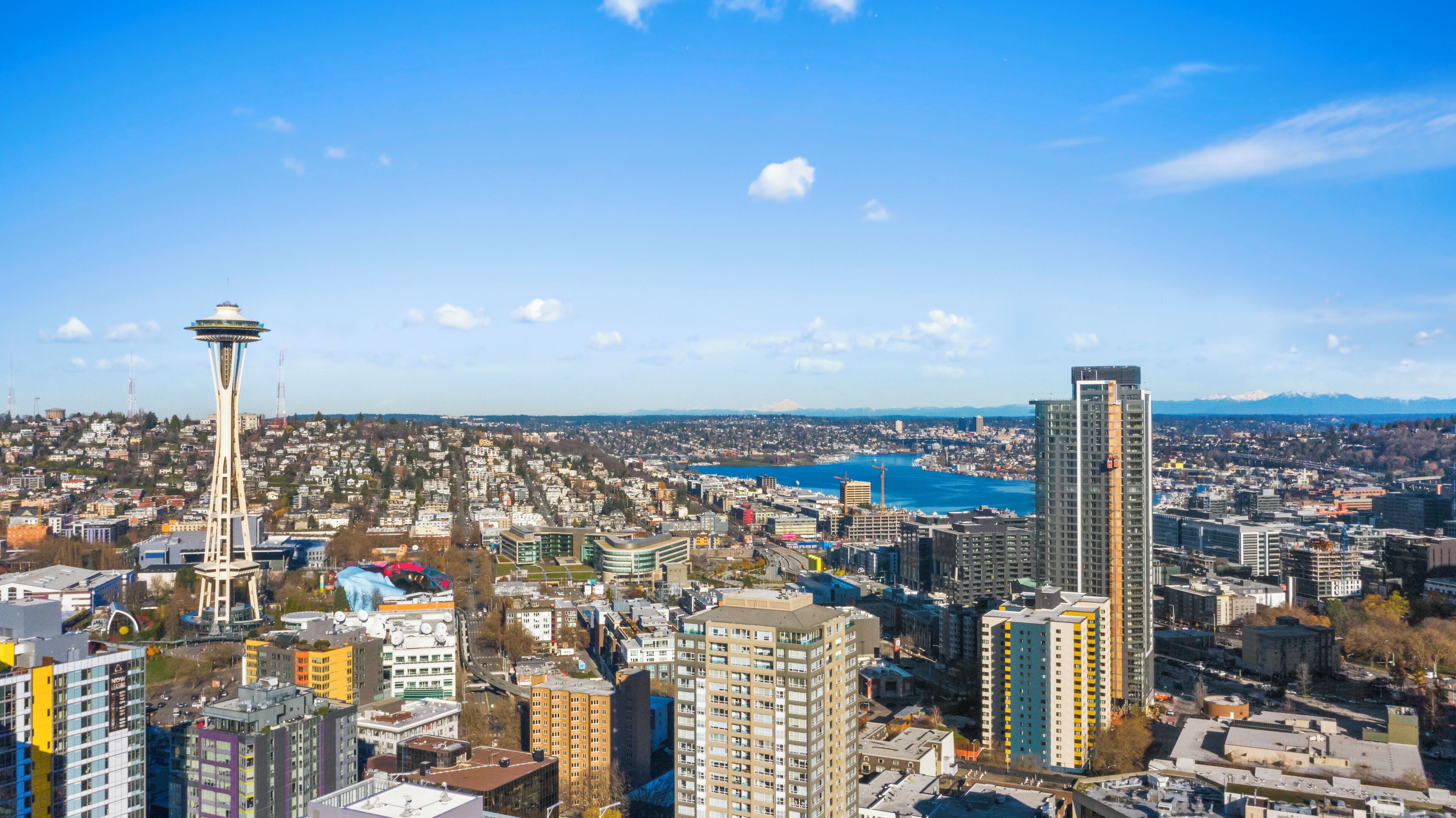 A cityscape with a prominent tower and a modern high-rise building.