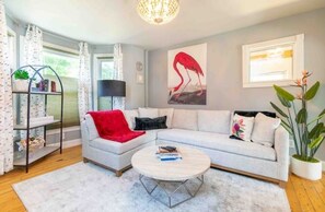 Relax in this stylish living room with a sofa, coffee table, bookshelf, and a beautiful painting.