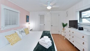 A bedroom with a bed, a TV, a dresser, and a ceiling fan. - Lake Hickory Trio 1 BR Pink Unit (Catawba County)