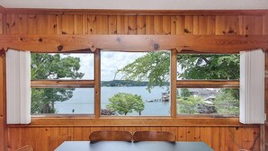 A room with a large window overlooking a lake, wooden walls, and a table with chairs. - Lake Hickory Trio 3BR Blue Unit (Catawba County)