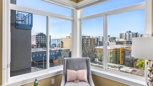 A corner room with a large bay window overlooking a cityscape. - Corner Unit in the Middle of It All (Seattle)