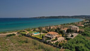 Una propiedad costera con piscina, varios edificios y vista al mar.