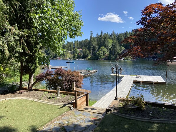 Une jetée au bord du lac, avec une passerelle en bois, entourée d’arbres et sous un ciel dégagé.