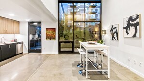 A modern kitchen with a dining area, large windows, and artwork on the walls. - Urban Loft in Redmond Core (Redmond)
