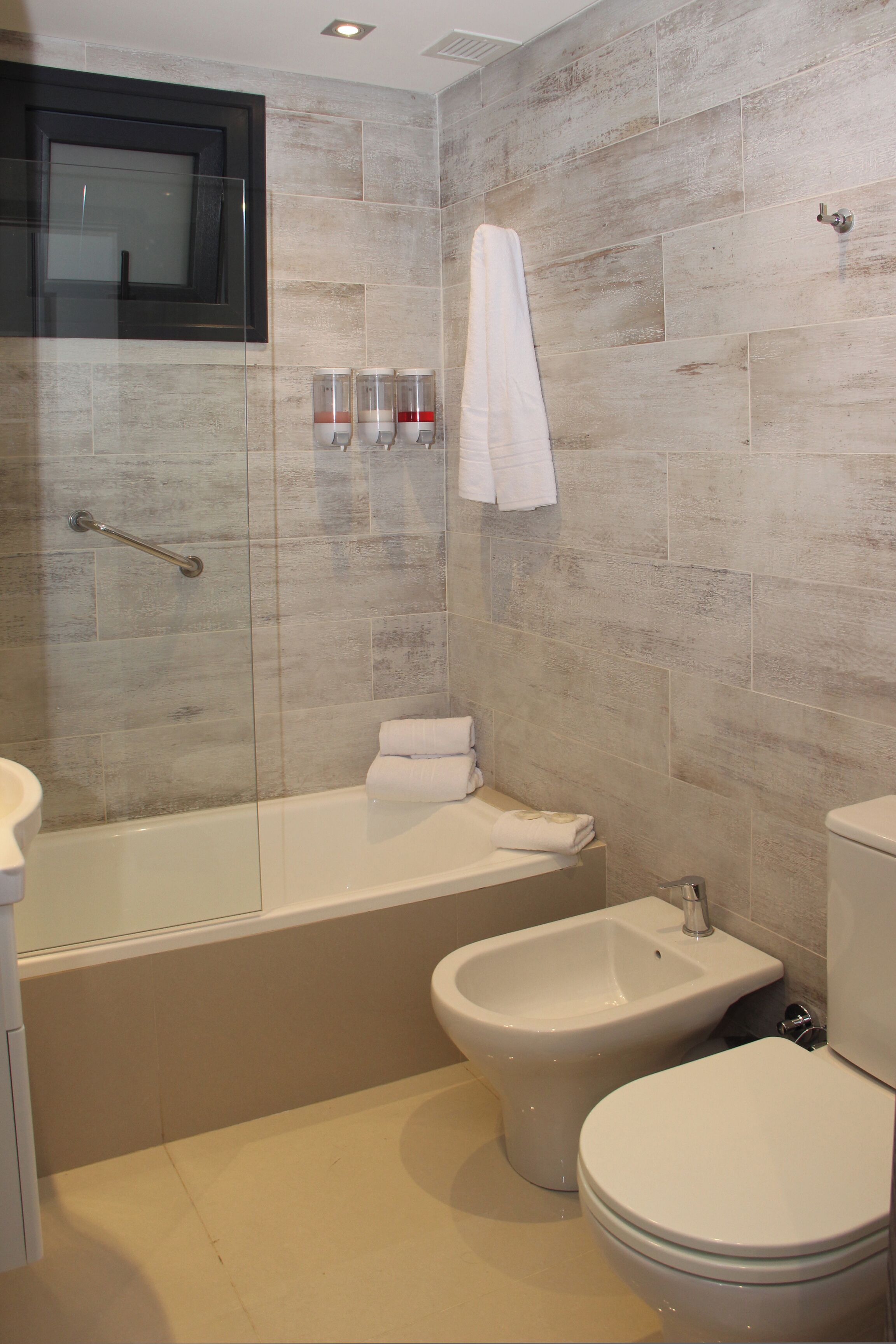 A bathroom with a bathtub, bidet, and toilet.
