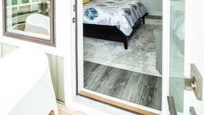 Een slaapkamer met een bed, een plafondventilator en uitzicht door een glazen deur.