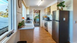 Una cucina moderna con frigorifero in acciaio inossidabile, mobili in legno e un'ampia finestra.