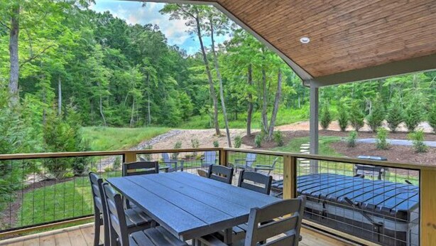 Un espace extérieur abrité, doté d’une terrasse en bois, de tables et de chaises.