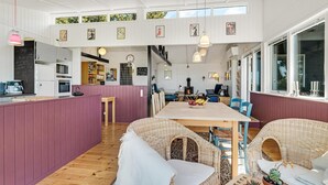 Een gezellig interieur met een eethoek, keuken en een zichtbare open haard.