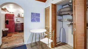A compact kitchen with a red refrigerator, a white table, and a blue starfish artwork on the wall. - Cozy Beach Studio – Sleeps 2, Walk to Ocean (San Diego)