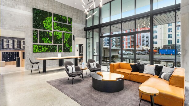 A modern lobby with a large window, seating area, and a wall with green foliage. - Posh Lofty Pad in Central Redmond (Redmond)