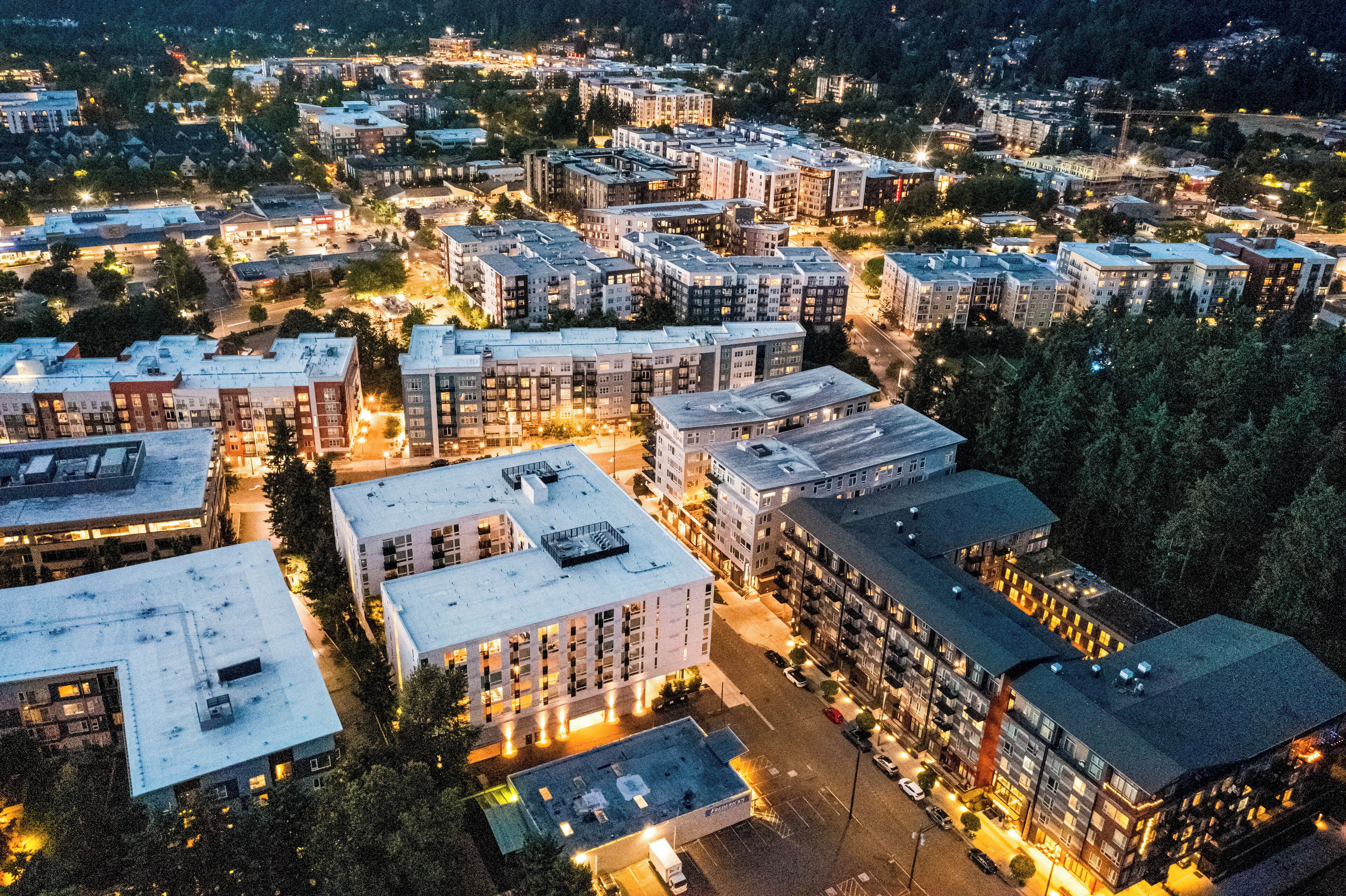 Vista aérea de una zona residencial con varios edificios de apartamentos, calles y zonas verdes.