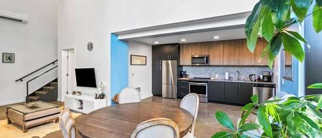 Una cocina moderna con gabinetes oscuros, un refrigerador de acero inoxidable y un microondas.