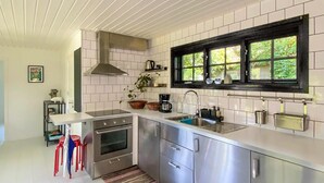 A modern kitchen with stainless steel appliances, a window with a black frame, and a tiled backsplash. - Gorgeous home in Skivarp with kitchen (Skivarp)