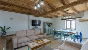 A living room with a sofa, a coffee table, and a dining area with a table and chairs. - Beautiful home in Buje (Buje)