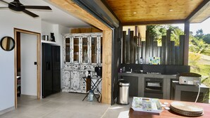 Eine moderne Küche mit Einbauofen, einem schwarzen Kühlschrank und einer Holzbalkendecke.
