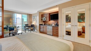 A hotel room with a large bed, a dining area, a kitchenette, and a sliding door closet. - The Suite Spot@MGM Signature Balcony Strip View (Las Vegas)