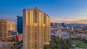 A high-rise hotel with a modern design, featuring a prominent curved top and multiple floors. - The Suite Spot@MGM Signature Balcony Strip View (Las Vegas)