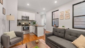 A modern apartment with a kitchen, dining area, and living room.